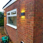 2 up down lights installed red brick wall