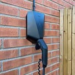 ease one charger black installed on brick wall near gate
